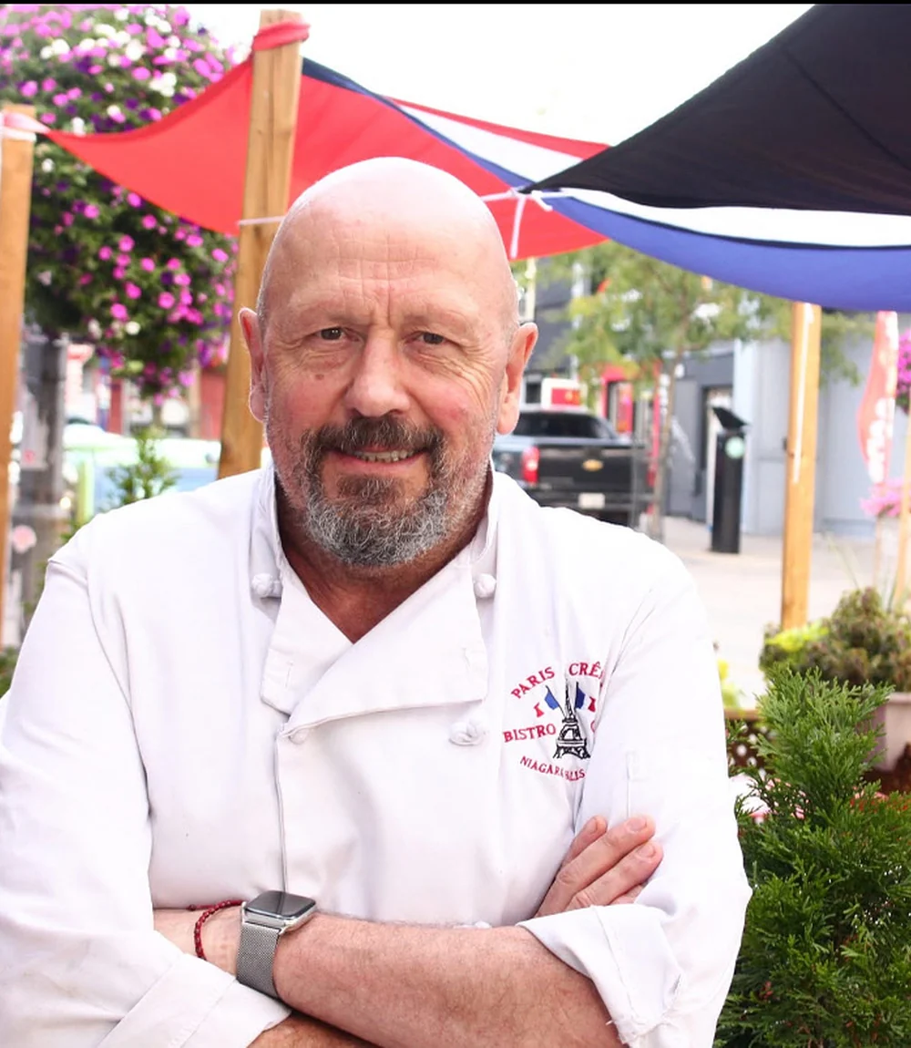 Chef Thierry Clement, owner of Paris Crêpes Café, in chef whites on the patio at 4613 Queen Street, Niagara Falls