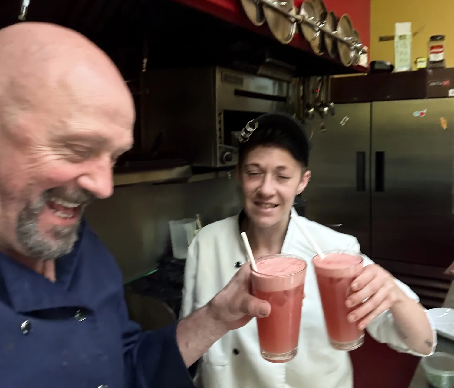 Chef Thierry Clement and head chef Jennifer sharing a toast in the kitchen at Paris Crêpes Café
