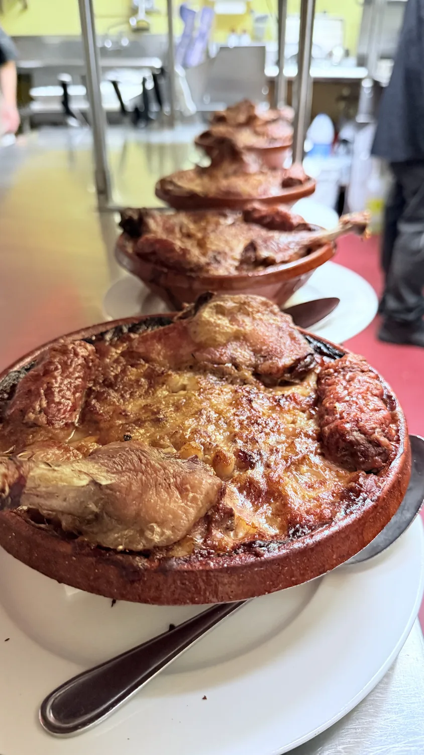 Duck confit baked in terracotta dishes in the kitchen at Paris Crêpes Café